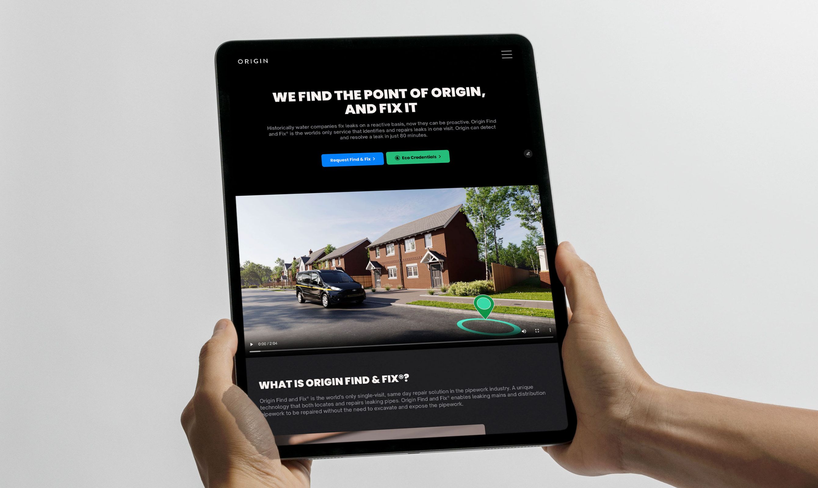 Hands holding a tablet showing the Origin site