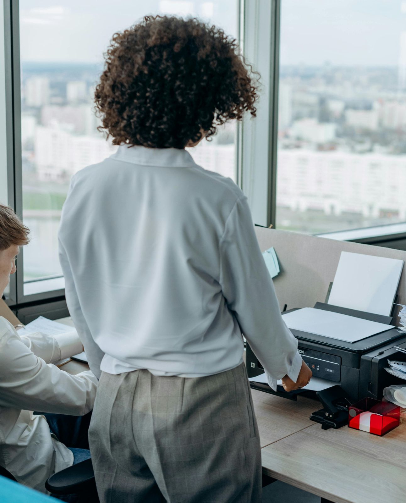Someone collecting a printout at an office window